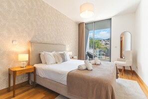 A hotel room with a bed, bedside table, lamp, and a view of the outside. - Funchal Frui Vita by Atlantic Holiday (Funchal)