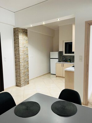 Une cuisine moderne avec un mur d’accent en pierre, un réfrigérateur et un évier.