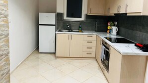 A compact kitchen with a refrigerator, sink, and stove. - Piraeus 3 in Piraeus (Piraeus)