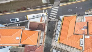 Una vista aerea di una strada fiancheggiata da edifici con tetti in tegole arancioni.