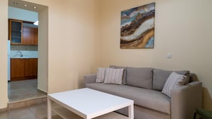 Een woonkamer met een bank, een salontafel en een schilderij aan de muur.