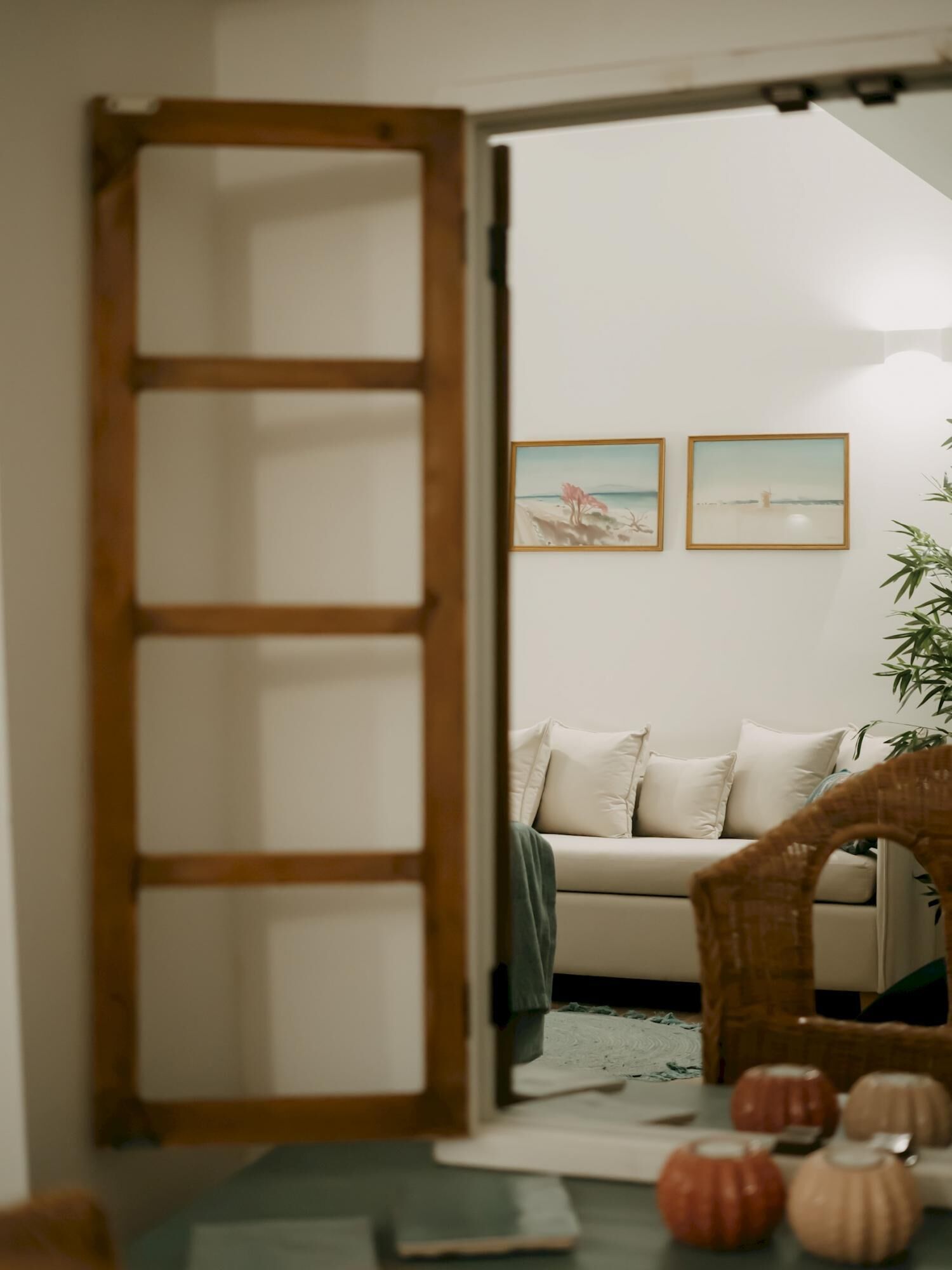 Ein Zimmer mit einer Couch, einer Holzleiter und zwei gerahmten Bildern an der Wand.