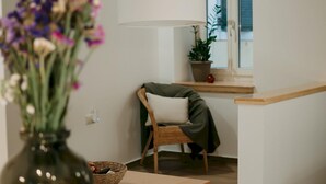 Un salon moderne avec une table en bois, un panier en osier et un vase de fleurs.