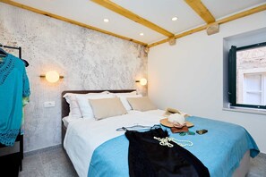 A bedroom with a bed, a window, and a wall with a textured pattern.