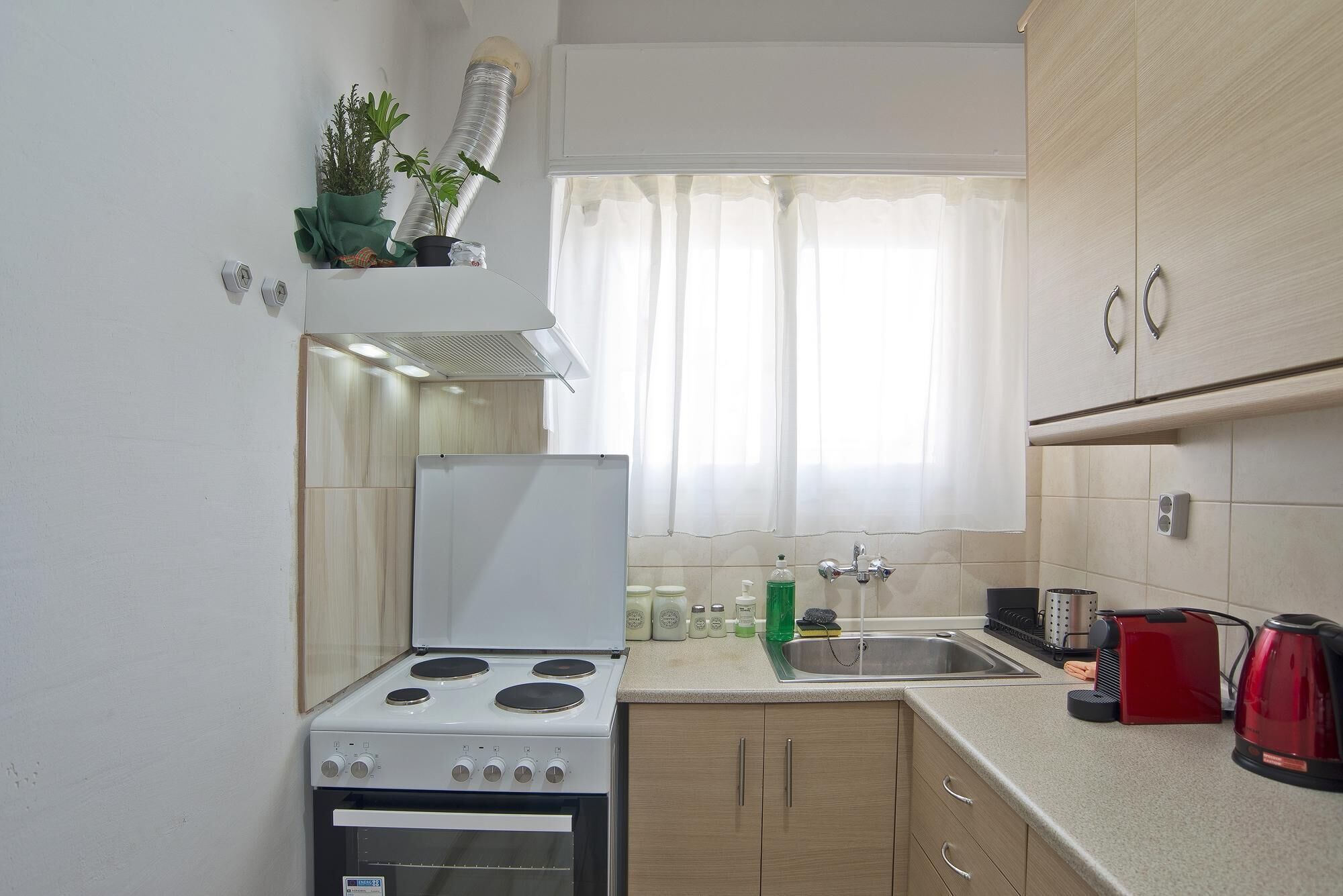 A compact kitchen with a stove, oven, sink, and cabinets.