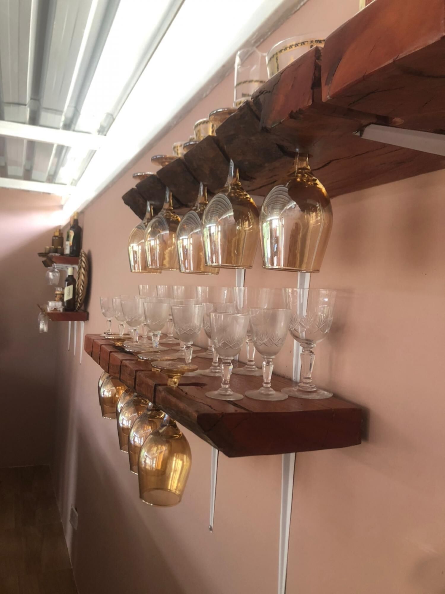 A wine rack with multiple wine glasses and bottles.