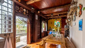 A rustic wooden interior with a large wooden table, a bench, and a tiled floor. - Chalet do Monte Porto Moniz by Madeira Sun Travel (Porto Moniz)