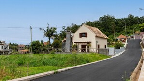 A rural road leading to a white house with a tiled roof and a stone chimney. - Chalet do Monte Porto Moniz by Madeira Sun Travel (Porto Moniz)