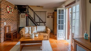 A cozy living room with a sofa, coffee table, and a brick wall. - Chalet do Monte Porto Moniz by Madeira Sun Travel (Porto Moniz)