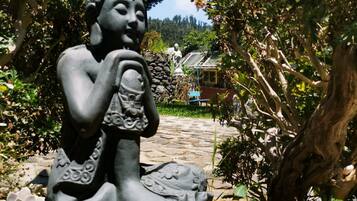 Una estatua de una figura sentada en un jardín.