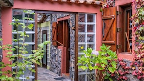 A building with a stone facade, wooden shutters, and a tiled roof. - Villa Achada da Mouca by Homie (Santana)