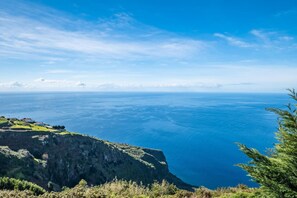A coastal landscape with a clear view of the ocean and a rocky cliff. - Ocean Panorama Apartment 2 by Homie (Calheta)