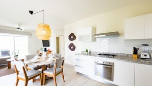 Una cucina moderna con mobili bianchi, un piano di lavoro in granito ed elettrodomestici in acciaio inossidabile.