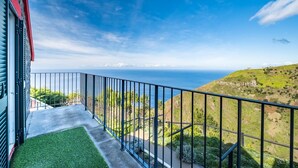 A balcony with a view of the ocean and a hilly landscape. - Ocean Panorama House by Homie (Calheta)