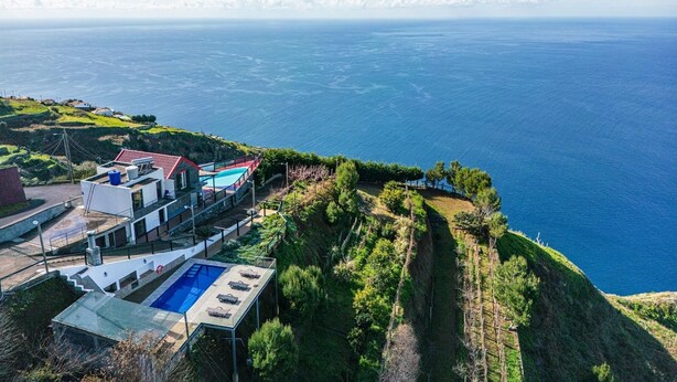 A coastal property with a swimming pool, a red-roofed building, and a view of the sea. - Ocean Panorama House by Homie (Calheta)