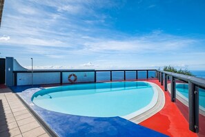Ein Pool mit gewölbter Kante, einem Rettungsring und einer Geländer.