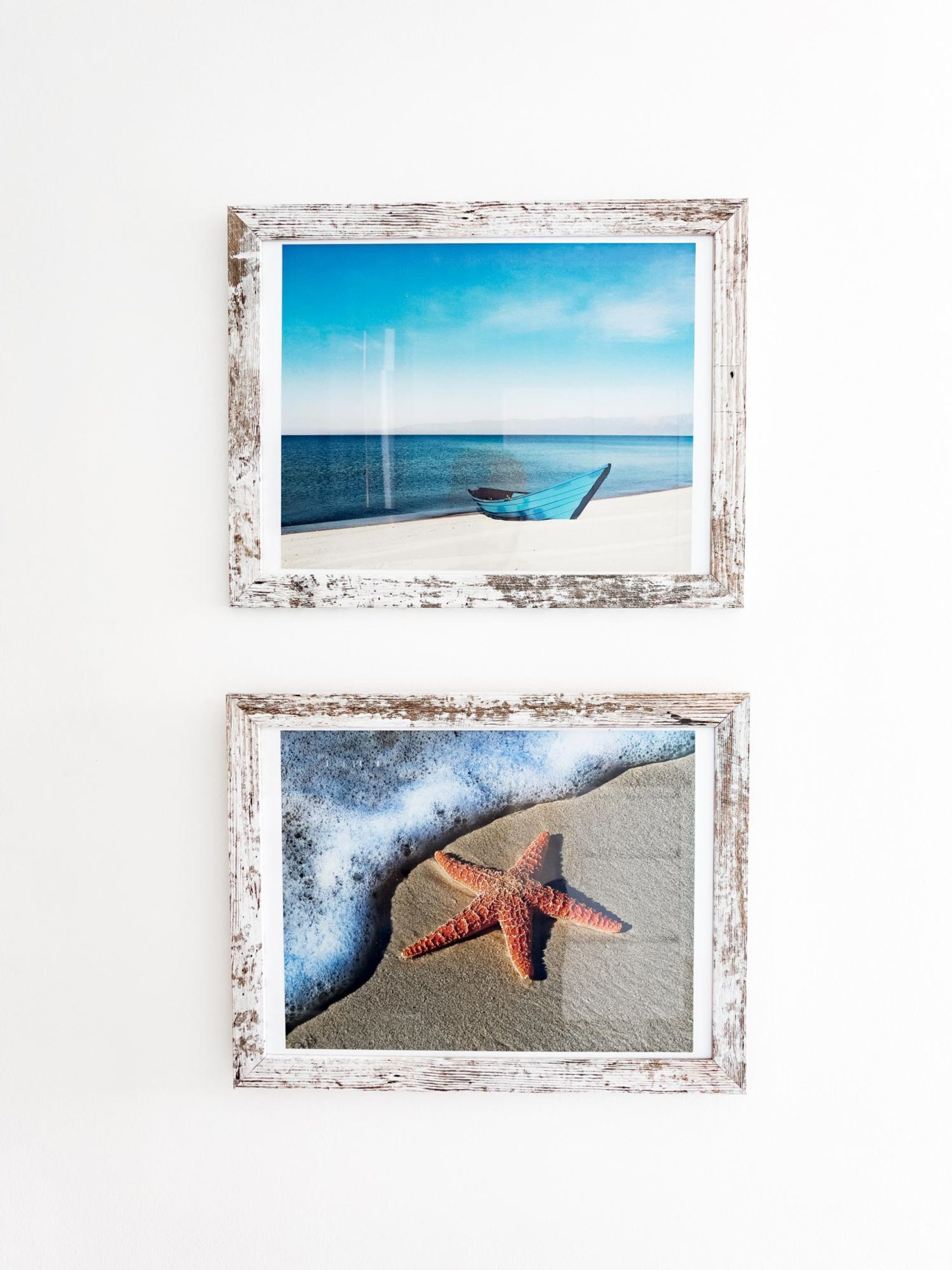 Two framed pictures: one of a beach with a hammock and the other of a starfish on sand.