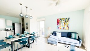 A modern kitchen with a dining area, a sofa, and a colorful abstract painting. - Residences C14-1d in Chame (Punta Chame)