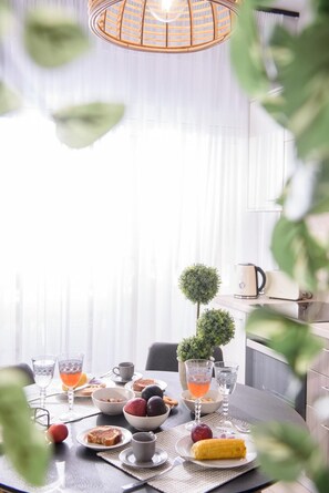 A dining table set with various dishes, glasses, and a small potted plant. - Casa Kali 1 Apartment (Heraklion)