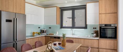 A modern kitchen with wooden cabinets, stainless steel appliances, and a central island with seating.