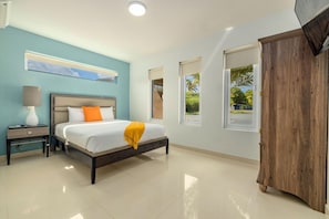 A bedroom with a bed, nightstand, lamp, and wardrobe. - Koyari Modern Condos 1 (Noord)