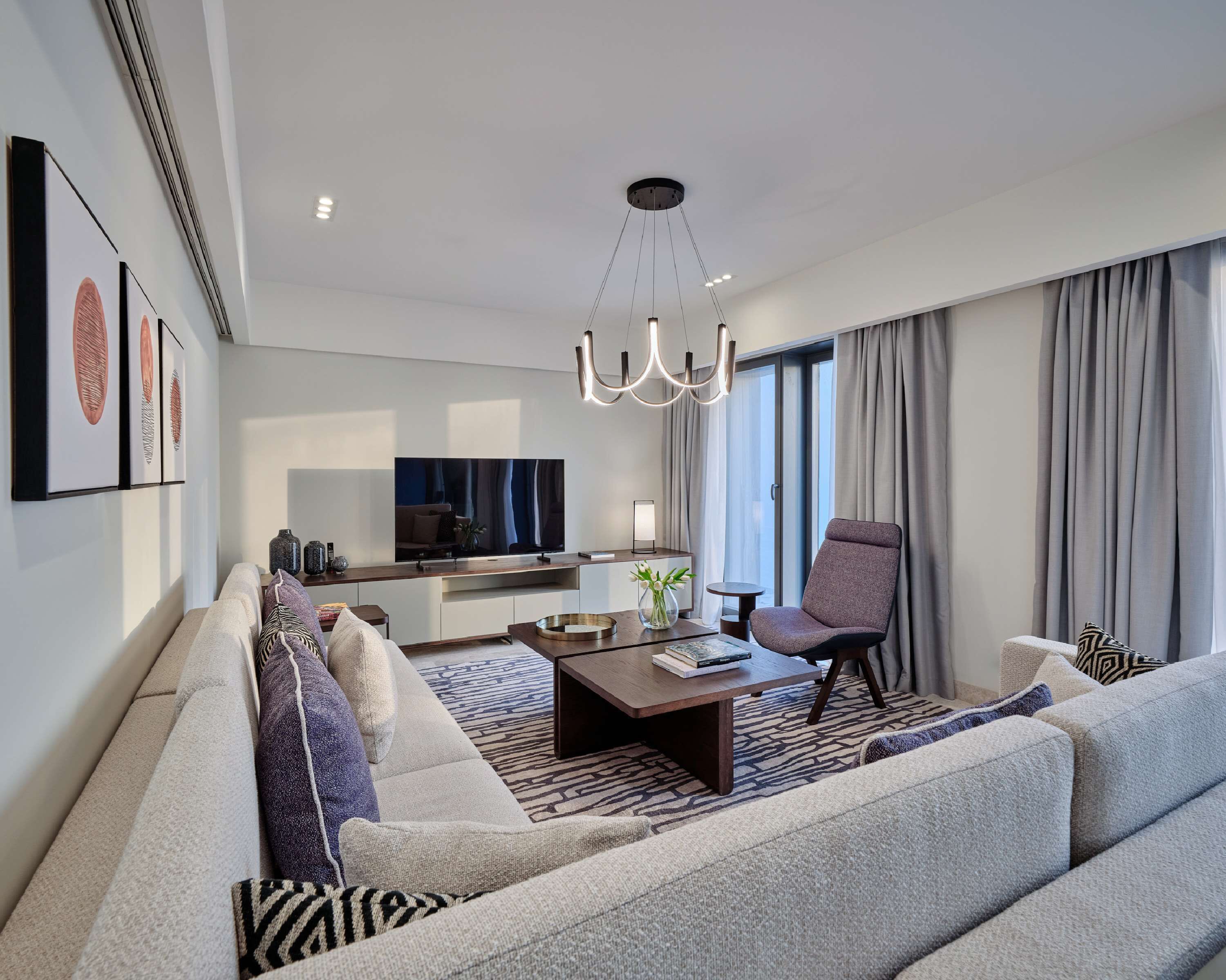 Ein modernes Wohnzimmer mit einer Couch, einem Couchtisch und einem Fernseher.