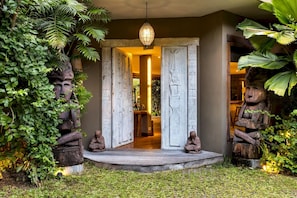 Enter a serene oasis surrounded by lush greenery and intricately carved stone figures.