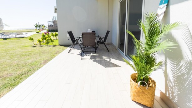 A balcony with a table and chairs, a potted plant, and a view of the ocean. - Residences C12-pbb in Chame (Punta Chame)