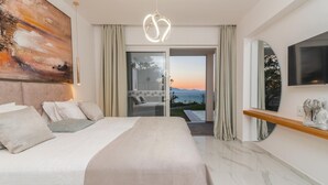 A modern hotel room with a large bed, a painting, a view of the sea, and a TV on the wall.