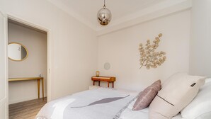 Une chambre à coucher avec un lit, une table de chevet et un miroir fixé au mur.