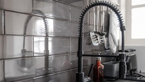 Una cocina con un grifo moderno, un lavabo y un escurreplatos.