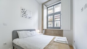 A modern bedroom with a bed, a window, and a wall-mounted artwork. - Nomad s Formosa Comfort - 1bed Porto (Porto)