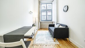 A small, bright room with a table, a couch, and a window. - Nomad s Formosa Comfort - 1bed Porto (Porto)