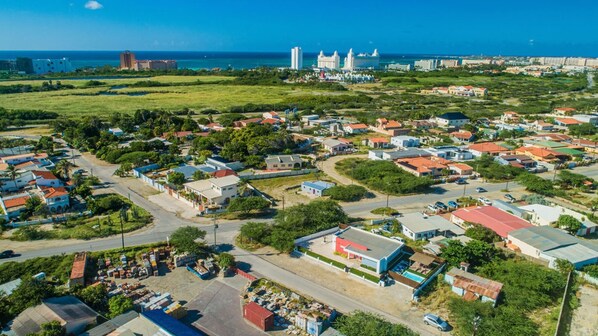 An aerial view of a residential area with houses, roads, and a large body of water in the background. - Viva Koyari Modern House (Noord)