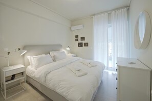 Una camera da letto ordinata con un letto, comodini, una scrivania e uno specchio.