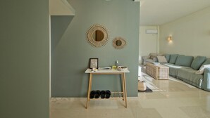 Ein modernes Wohnzimmer mit grauer Wand, einem Holztisch mit Spiegel und einem grauen Sofa.
