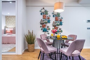 A modern dining area with a round table, four chairs, and a decorative wall with various objects.