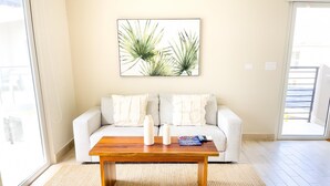 A living room with a sofa, a coffee table, and a painting on the wall. - Residences C4-1c in Chame (Punta Chame)