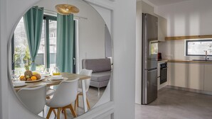 Eine moderne Küche mit einem Edelstahl-Kühlschrank, einer Holzarbeitsplatte und einem Fenster mit Blick auf einen Garten.