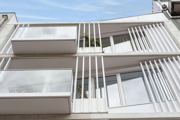 Un edificio moderno con varios balcones y amplias ventanas.