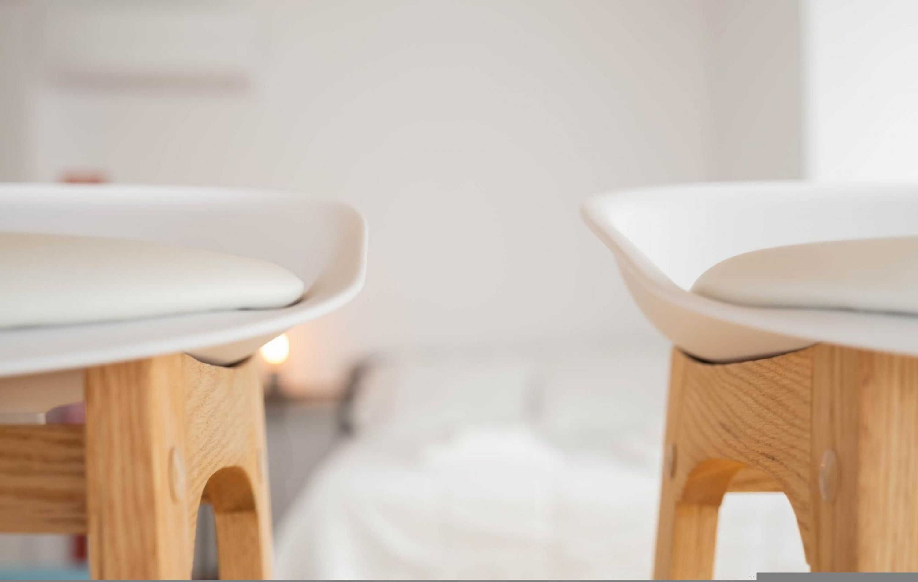 To træborde med hvide bordplader, sandsynligvis i et hotelværelse.