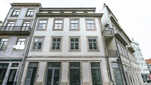 A multi-story building with a symmetrical facade, large windows, and a ground-floor entrance with a glass door. - Nomad s Formosa Harmony - 1bed Porto (Porto)