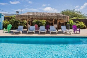 Relax by the pool in a shaded area with comfortable lounge chairs.