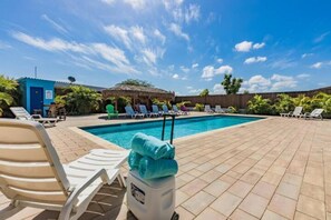 Relax by the pool surrounded by lush tropical plants and comfortable lounge chairs.