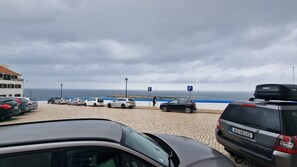 Een parkeerplaats met auto's en uitzicht op zee.