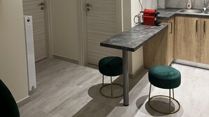 Une cuisine moderne avec deux portes, un plan de travail, un évier et un appareil électroménager rouge.
