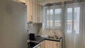 A compact kitchen with a Bosch refrigerator, a stove, and a sink. - Adelais in Piraeus With 1 Bedrooms and 1 Bathrooms (Piraeus)