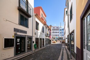 Une ruelle étroite pavée, bordée d’immeubles, dont un magasin appelé « Loja ConzaLez », dont l’entrée est bien visible et qui affiche une enseigne indiquant le numéro de pièce 30.