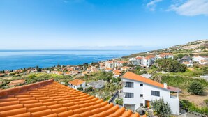 Un pueblo costero con edificios de techos de teja anaranjada, vista al mar y una combinación de construcciones residenciales y comerciales.