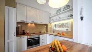 A kitchen with white cabinets, a wooden countertop, and a fruit bowl. - Apeiron I Villa - Instaworthy Views Ace Location (Paxos)